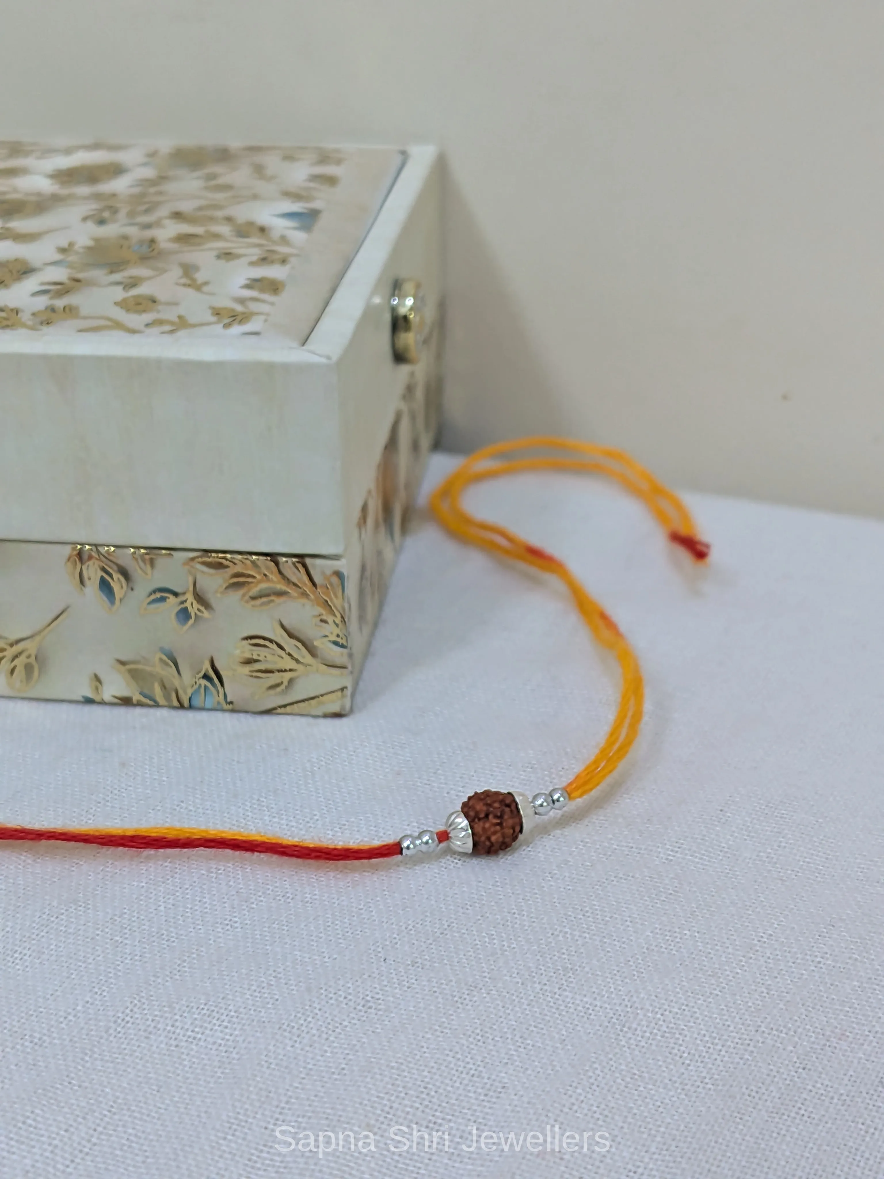 925 Silver Rudraksha Rakhi with Yellow & Red Mauli Thread - Image 1 of 4 925 Silver Rudraksha Rakhi with Yellow & Red Mauli Thread - View 1