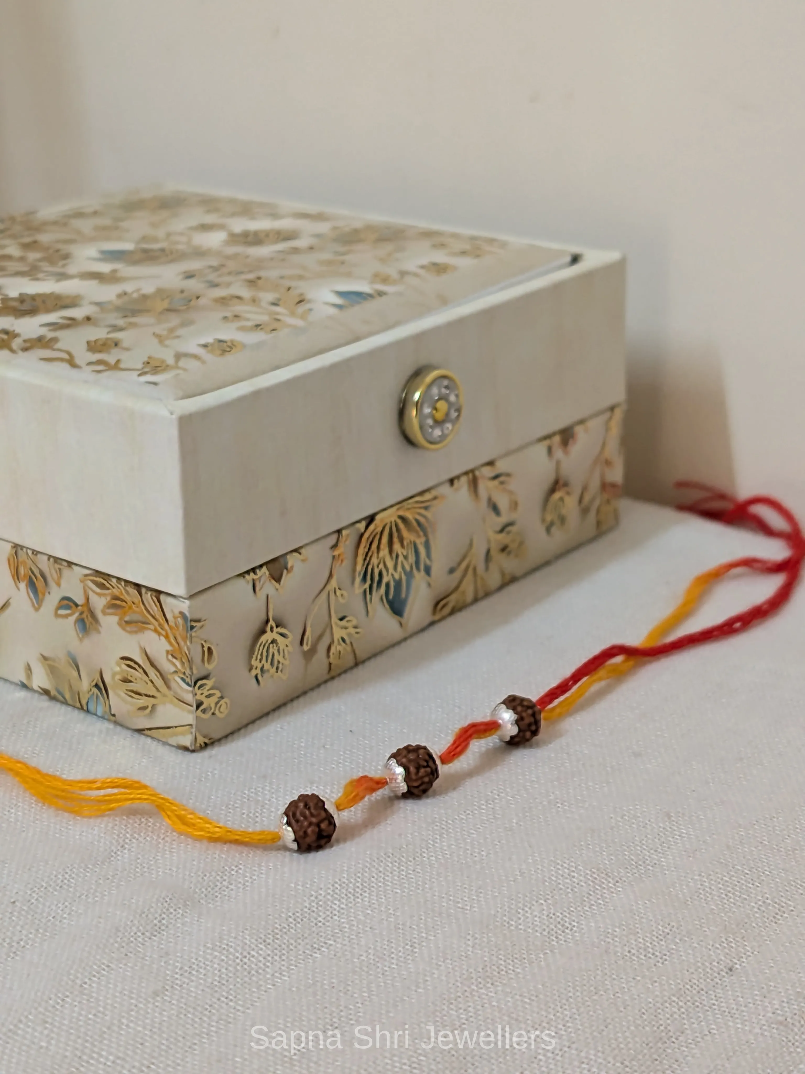 Three Rudraksha Silver Rakhi – Red & Yellow Spiritual Rakhi - Image 1 of 4 Three Rudraksha Silver Rakhi – Red & Yellow Spiritual Rakhi - View 1