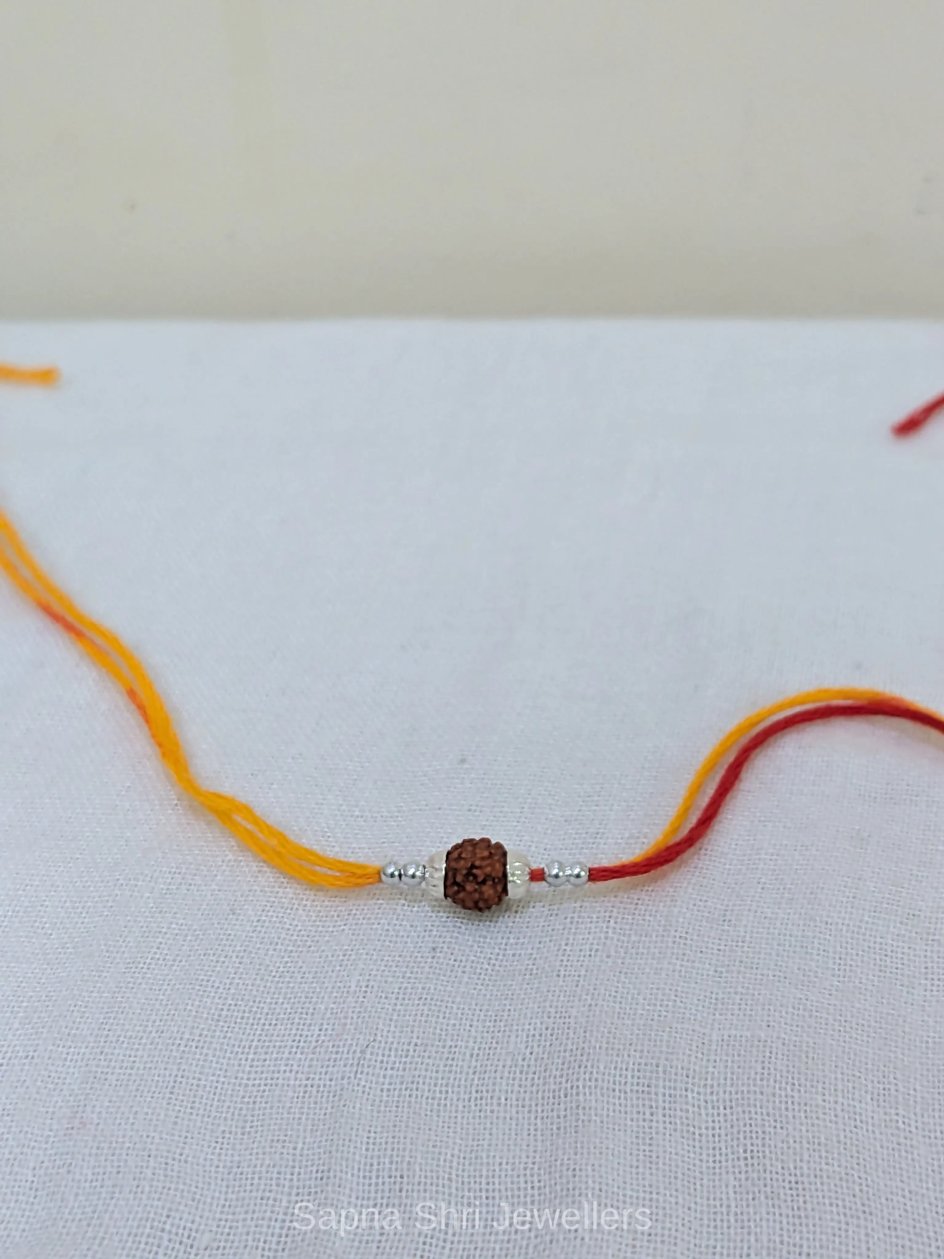 925 Silver Rudraksha Rakhi with Yellow & Red Mauli Thread thumbnail 2