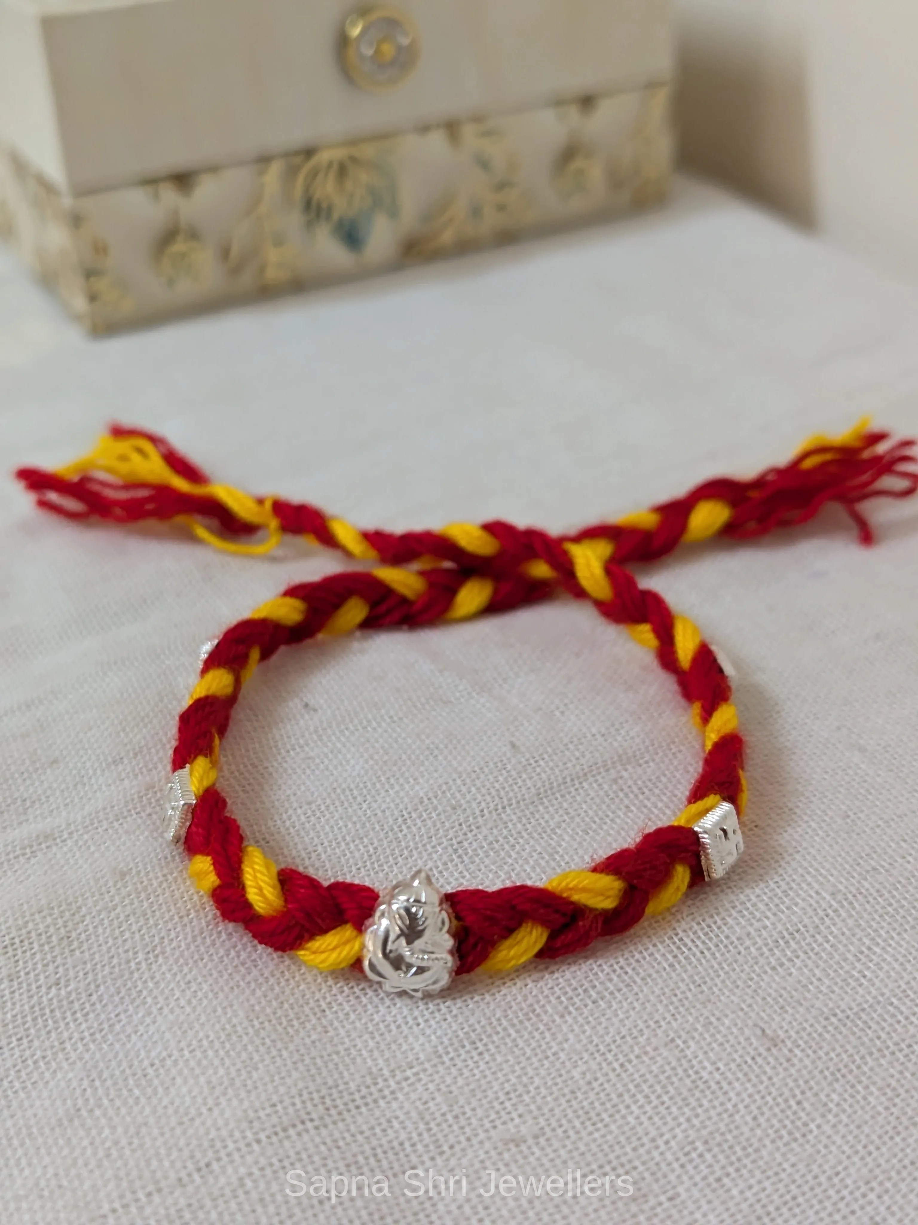 Ganesh Silver Rakhi – Red & Yellow Mauli Rakhi for Brother thumbnail 4